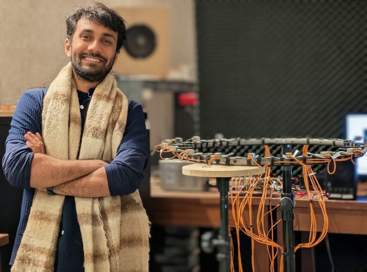 Portrait beside the curved MEMS microphone array used for acoustic imaging
