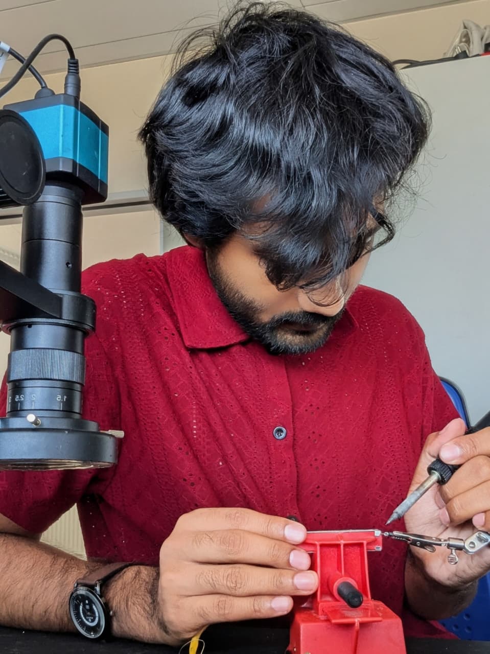 Shahariar Ryehan soldering a MEMS test fixture under a microscope